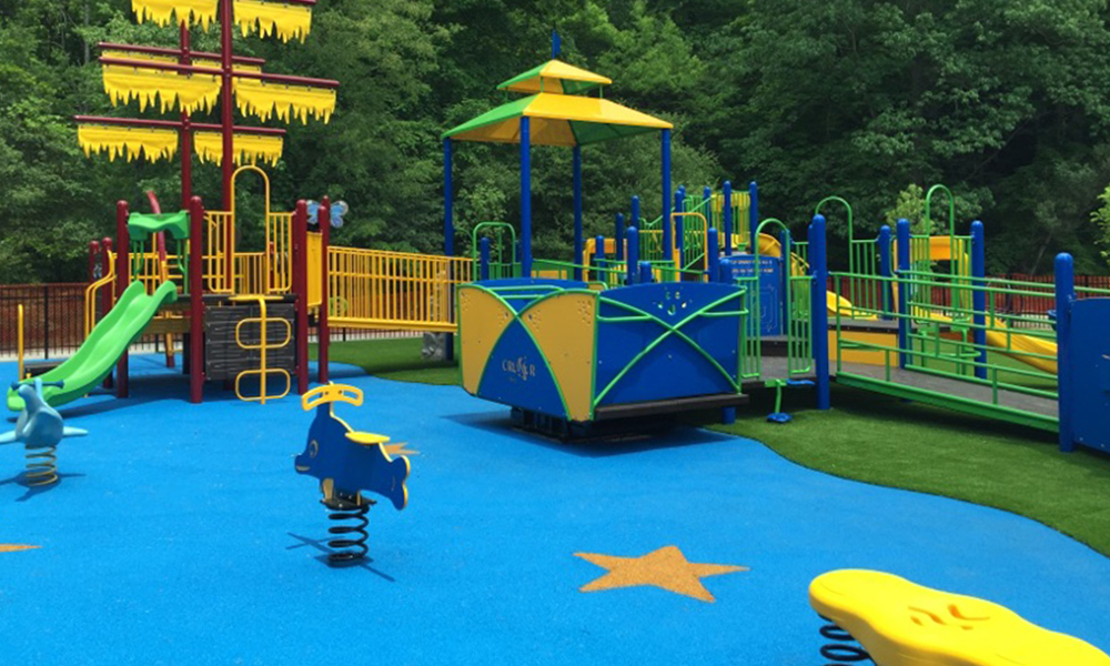 Playground featuring turf and rubber playground safety surfacing